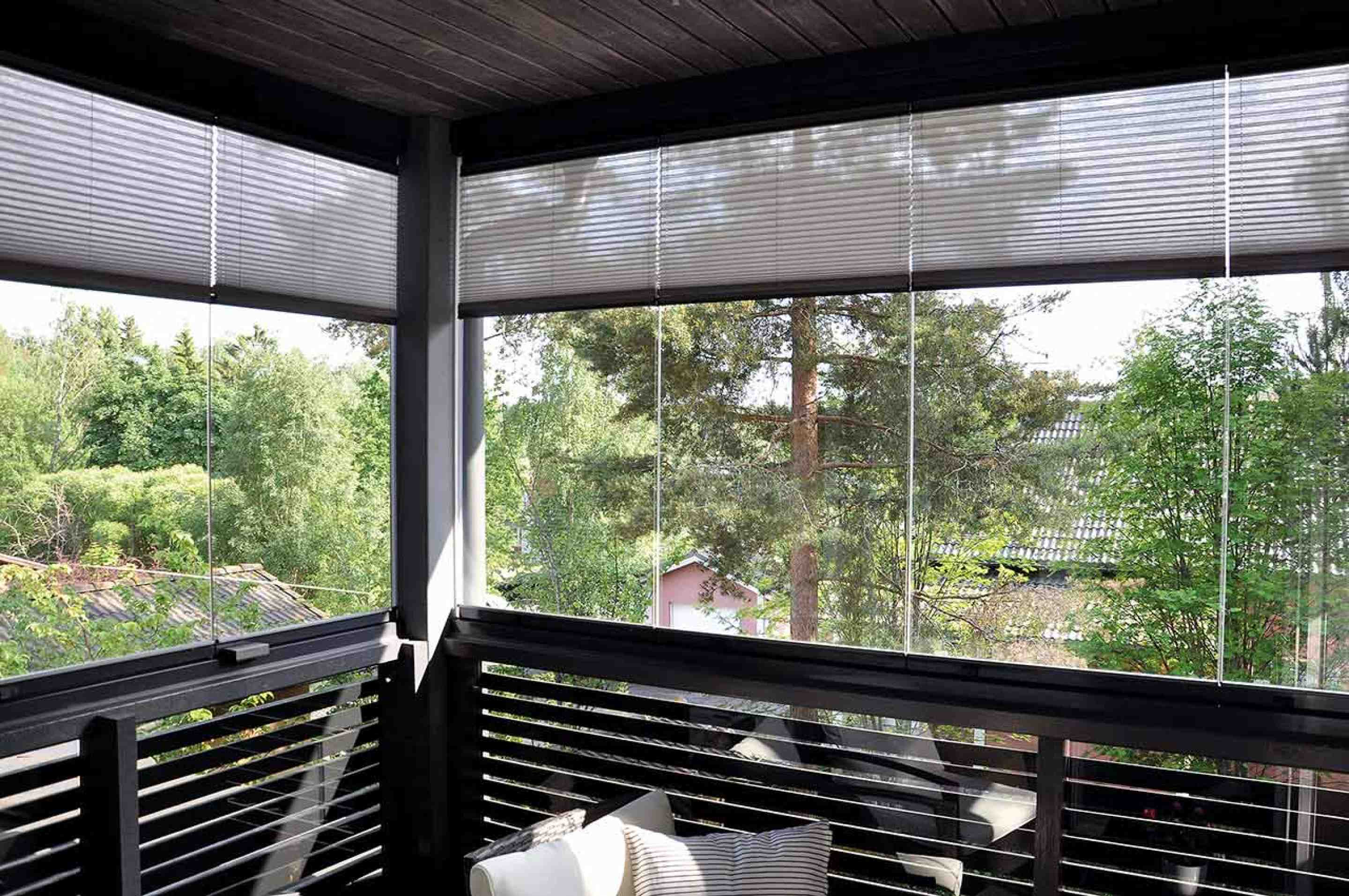 balkong med inglasade fönster och skogsvy