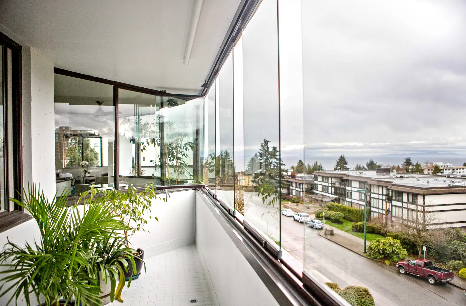 Vit balkong med inglasade fönster