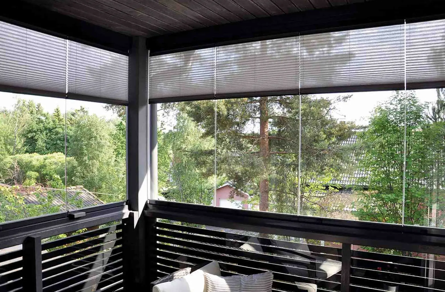 balkong med inglasade fönster och skogsvy